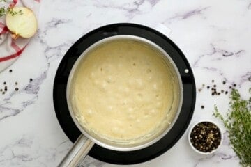 Cream sauce with bubbles in saucepan.