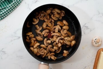 Sauteed mushrooms in skillet with herbs.