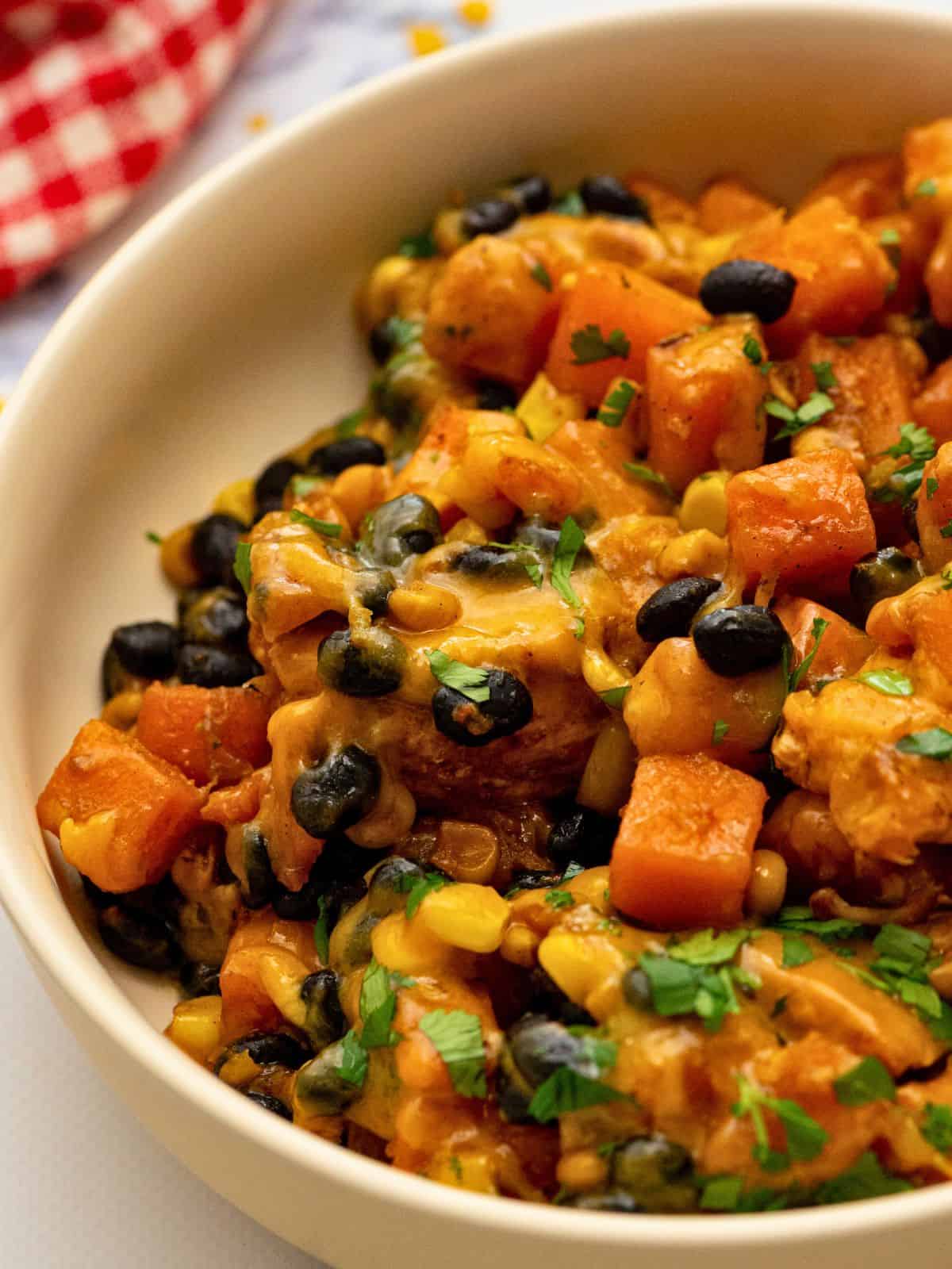 Cheesy Chicken and Sweet Potatoes with Beans and Corn served in large bowl.