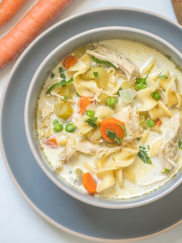 Bowl of Creamy Instant Pot Turkey Noodle Soup topped with fresh parsley.