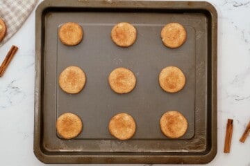 Baked Snickerdoodles on baking sheet.