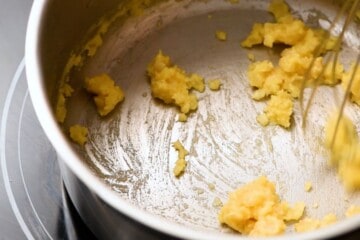 Saucepan with flour and butter being whisked together to form a roux or paste.