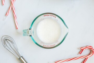 Frothed milk in glass measuring cup.