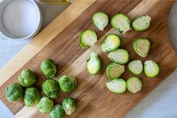 Prepared Brussel Sprouts on wooden cutting board.