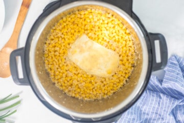 Instant Pot with creamed corn ingredients after pressure cooking but before stirring together.