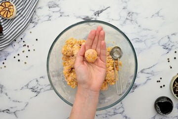 Hand showing a sausage ball rolled from 1 tablespoon of the mix.