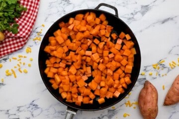 Cubed sweet potatoes in skillet after sautéing.