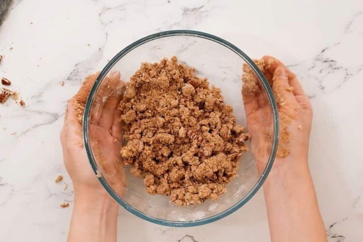 Mixing bowl with buttery cinnamon streusel combined to look like wet sand in mixing bowl.