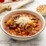 Bowl of slow cooker minestrone topped with parmesan cheese.