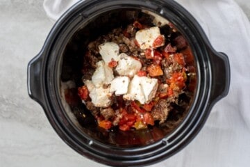 Browned sausage in crockpot with Rotel Tomatoes and Cubed cream cheese.