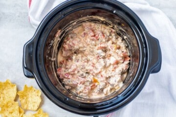 Cheesy sausage dip in slow cooker after cream cheese has melted.