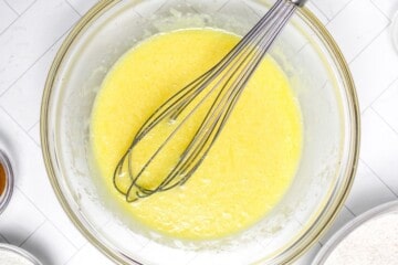 Mixing bowl with orange juice, melted butter, eggs, and vanilla mixed together.