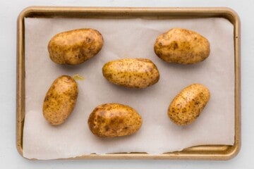 Russet Potatoes on baking sheet rubbed with olive oil and salt.