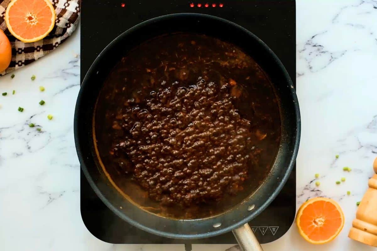 Orange Chicken sauce bubbling in saute pan.