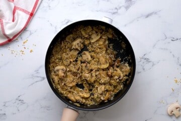Mushrooms, onions, and rice toasted in saucepan.