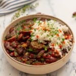 Instant Pot Red Beans and Rice served together in cream bowl topped with parsley.