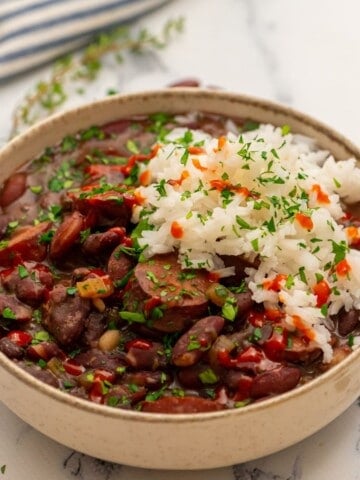 Instant Pot Red Beans and Rice served together in cream bowl topped with parsley.