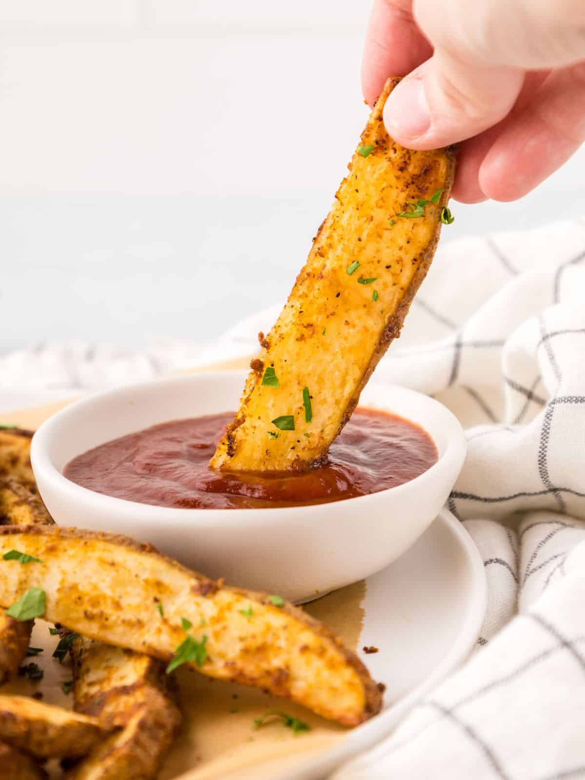 Baked French Fry being dipped into ketchup.