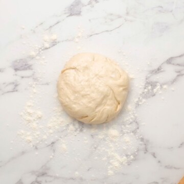 Pizza Dough in ball on floured surface.
