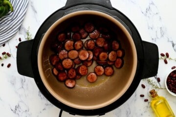 Sliced andouille sausage sauteed inside inner pot of Instant Pot.