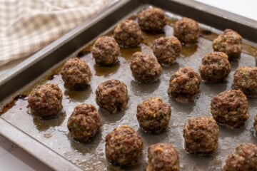 Rimmed Sheet pan with perfectly baked meatballs.