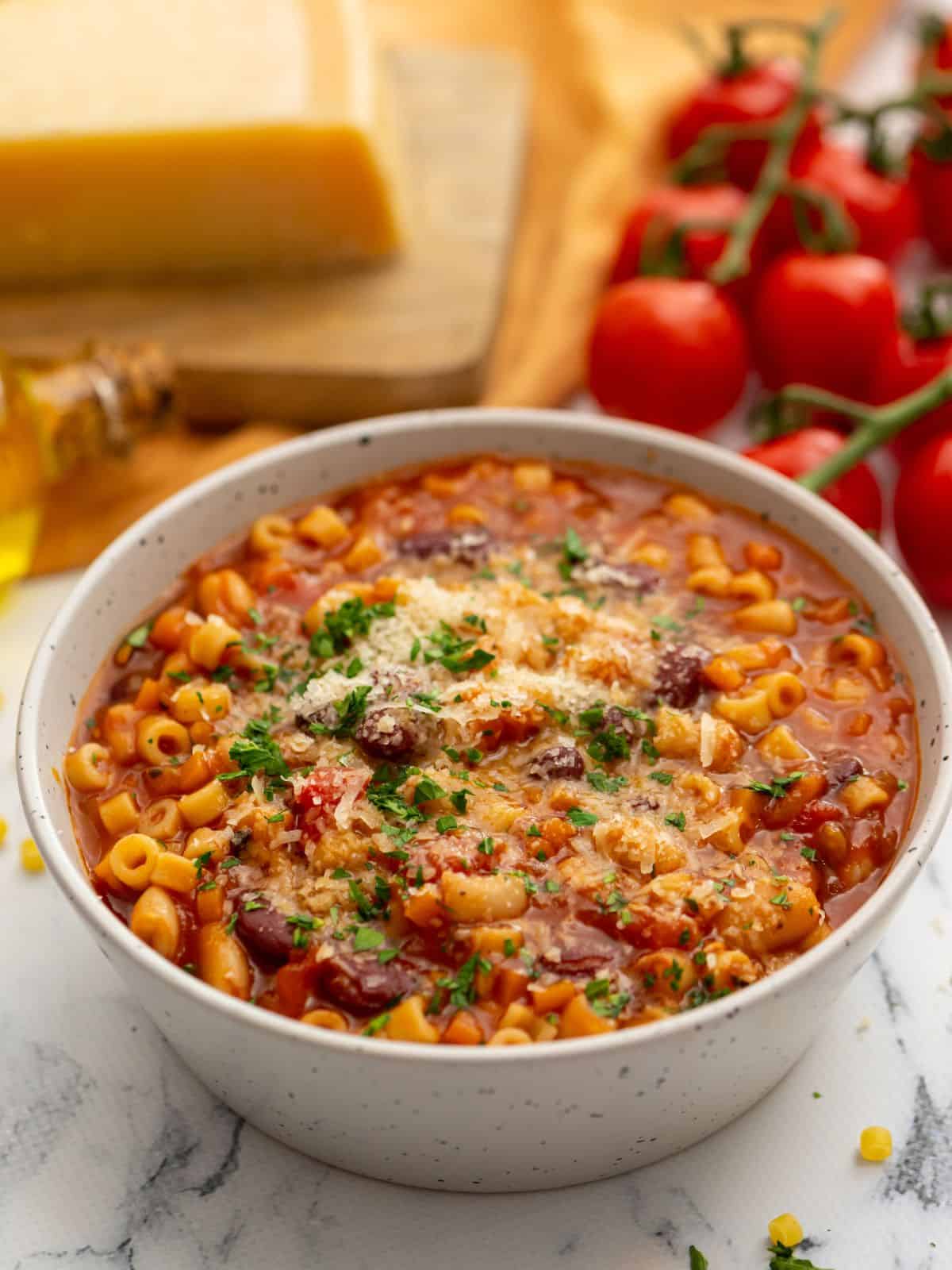 Bowl of pasta fagioli topped with parmesan cheese.