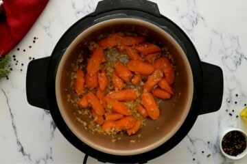 Carrots and onions sauteed in inner pot of Instant Pot.