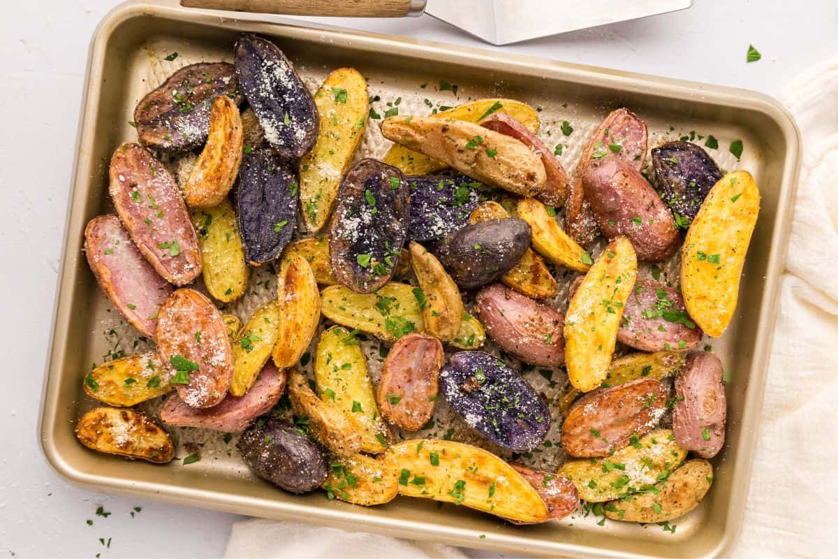 Rimmed Sheet Pan with roasted fingerling potatoes topped with parsley and parmesan.