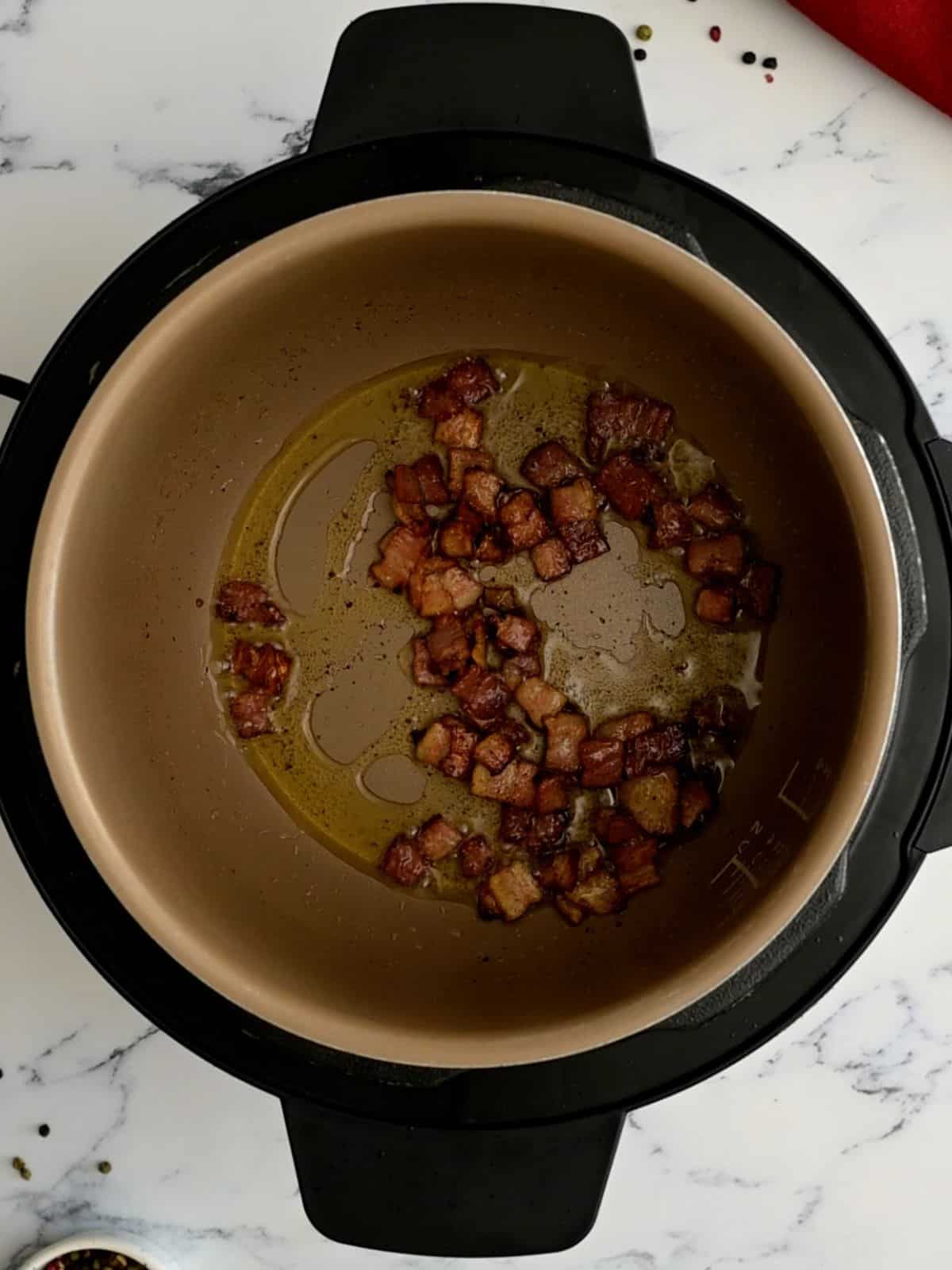 Sauteed bacon inside inner pot to start Beef Bourguignon.