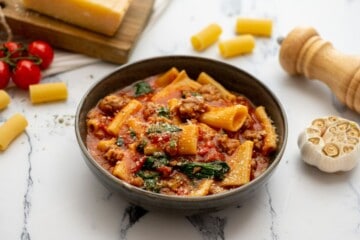 Bowl of Instant Pot Rigatoni with sausage topped with parmesan cheese.