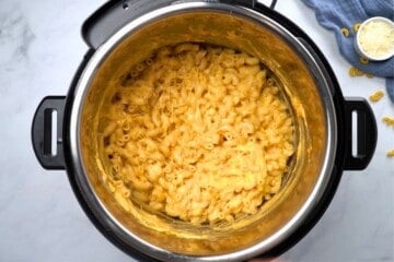 Instant Pot filled with cooked elbow noodles after adding cheese and sour cream to make mac and cheese.