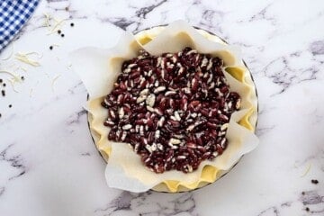 Pie crust lined with parchment paper and dried beans.