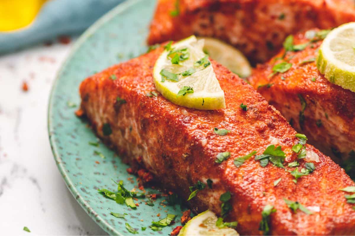Fish Recipes for Picky Eaters Spice rubbed salmon on blue plate with lime slices.
