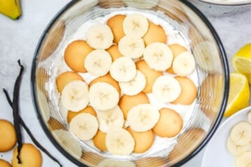 Layered vanilla pudding with vanilla wafers, and sliced banana in a trifle dish.