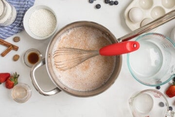 Small saucepan with milk, cream, cinnamon, nutmeg, and sugar whisked together.