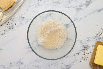 Yeast, sugar, and water foaming up in small mixing bowl.