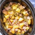 Slow cooker with ham, green beans, and potatoes inside crockpot.