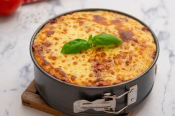 Lasagna in springform pan after being broiled in oven.