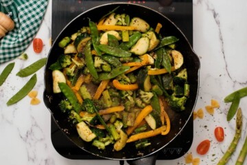 Sauteed vegetables in skillet seasoned with Italian seasoning and wine.