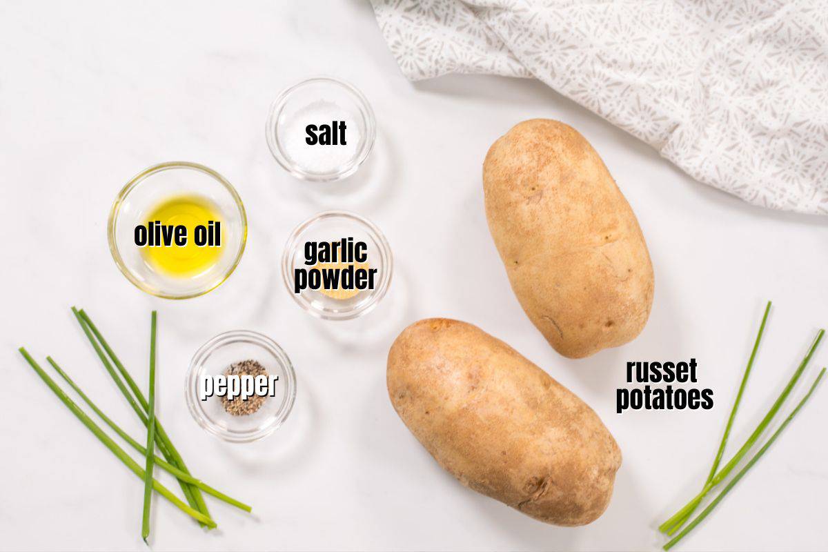 Ingredients needed for air fryer baked potatoes labeled on counter.