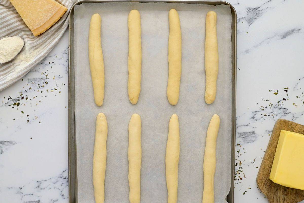 8 shaped breadsticks on parchment lined baking sheet before rising.
