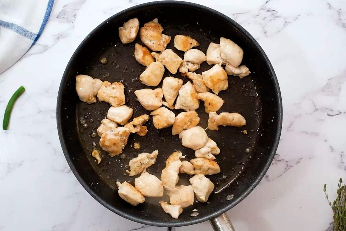 Chicken breast cubed in bite-sized pieces browned in skillet.