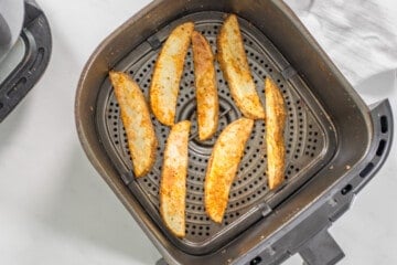 Seasoned potato wedges in a single layer after air frying until crispy.