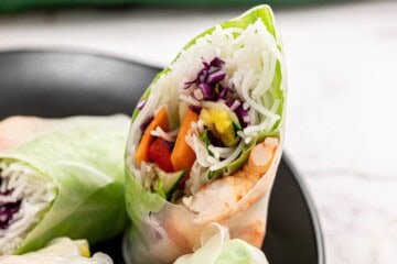Spring Roll Cut Open showing shrimp, mangos, bell peppers, and cabbage.