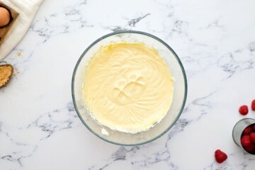 Creamy cheesecake filling in clear mixing bowl.