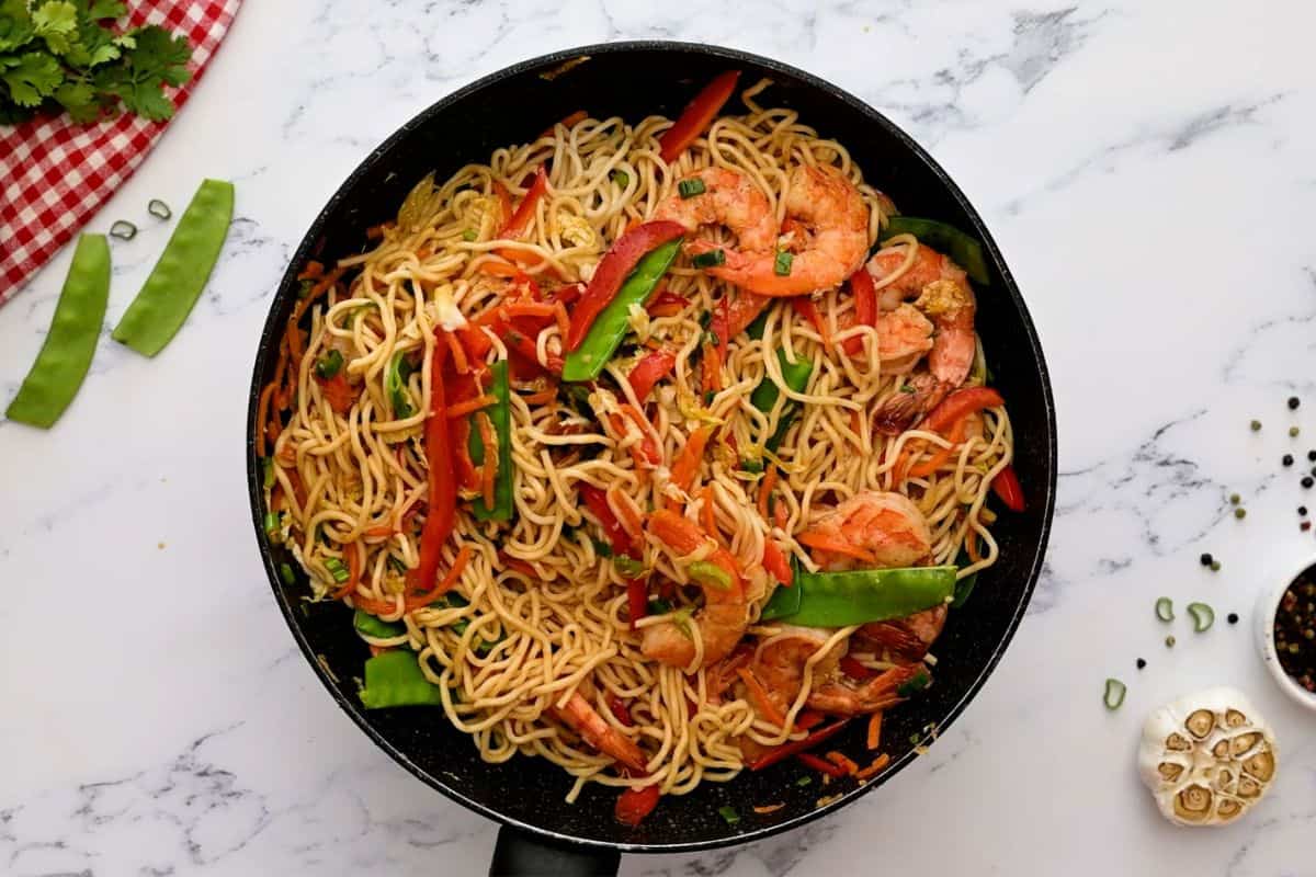 Shrimp, Lo Mein noodles, and vegetables in saute pan.