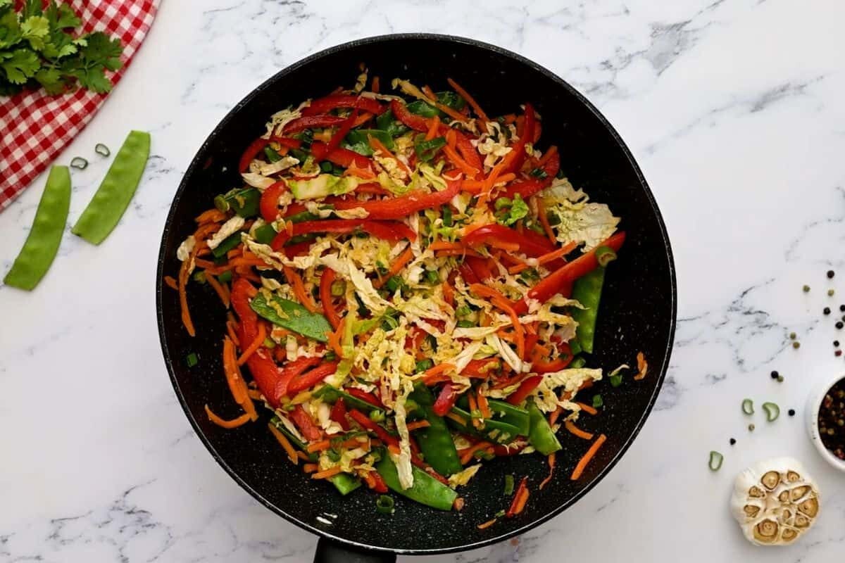 Sauteed veggies for shrimp lo mein in saute pan.