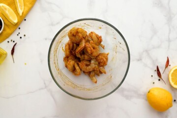 Raw shrimp mixed with seasonings, oil, and lemon zest.