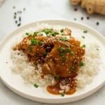 Instant Pot Teriyaki Chicken over white rice topped with sliced green onions.