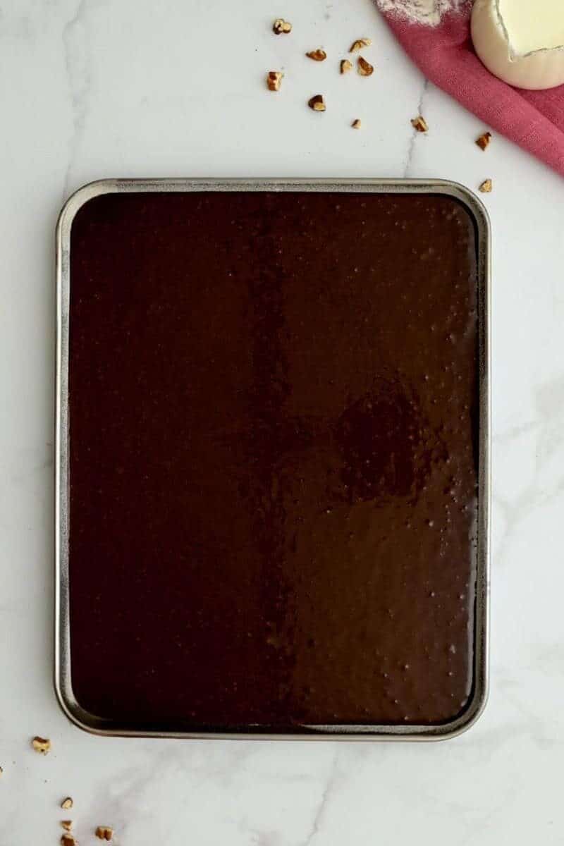 Texas Sheet cake batter spread out in greased and floured sheet pan.